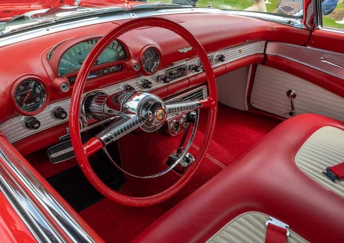 Rotes Interieur eines klassischen Oldtimers mit Lenkrad und Armaturenbrett in Lederoptik
